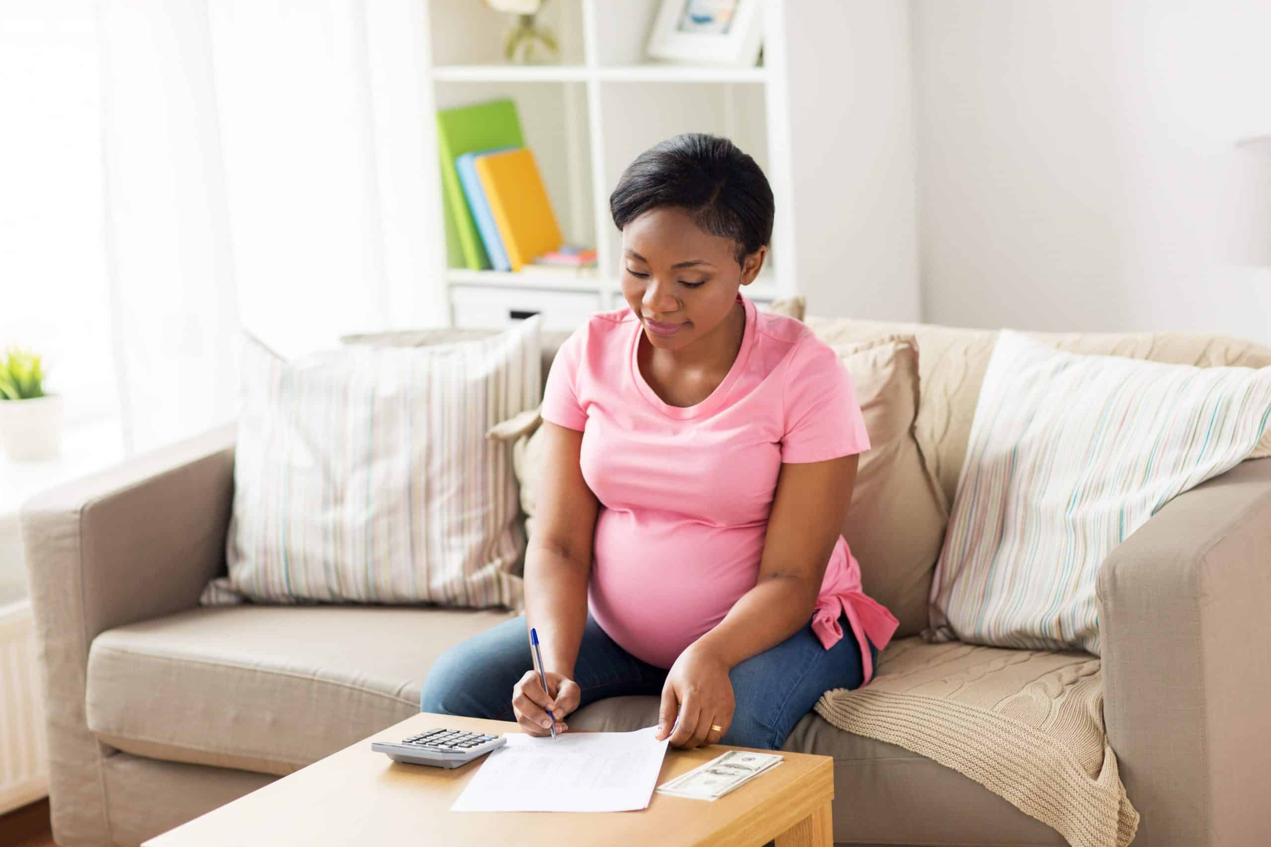 pregnant woman with bills and money at home