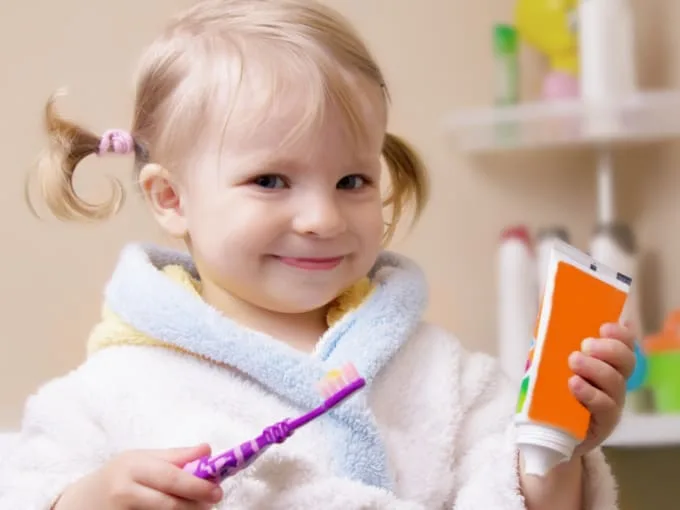 Smiling girl with toothbrush and tube in bathroom