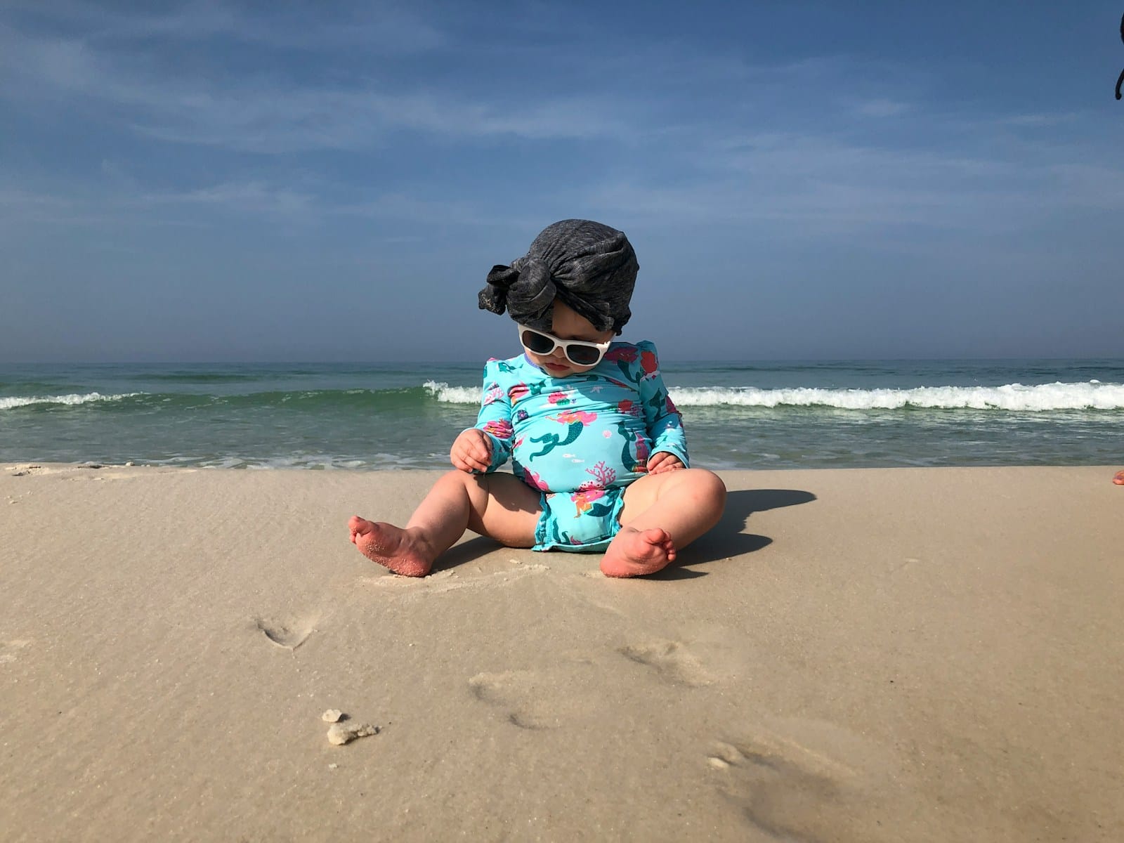 baby sitting near shore