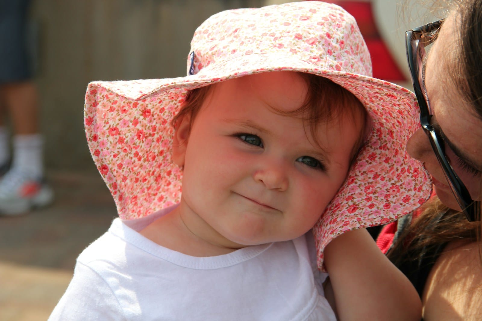 girl in white crew neck t-shirt wearing pink and white floral sun hat